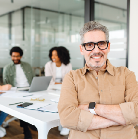 Man in an office surrounded by team members at a table