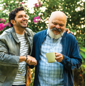 Young man with elderly father holding a cup of coffee