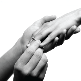 Man putting a ring on a woman's finger